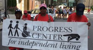 Members of the Progress Center Community holding a banner that reads "Progress Center for Independent Living" at the Disability Pride Parade in Chicago. 